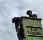 Petugas Sedang Memperbaiki Penerangan Lampu Jalan yang Rusak/ Foto : Juno